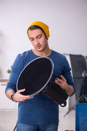 Young male photographer working in the studio