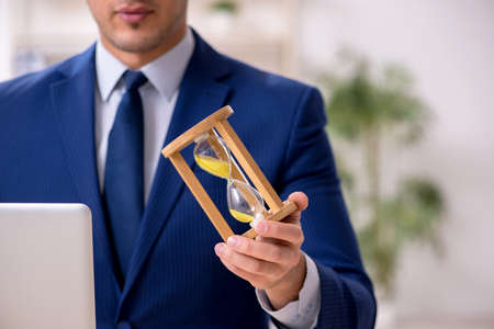 Young male employee in time management concept