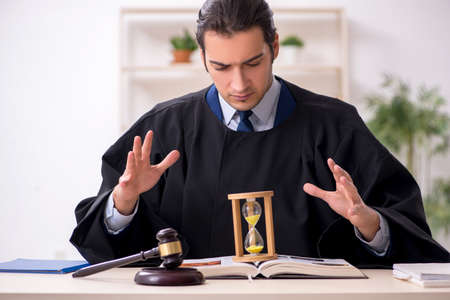 Young male judge in time management conceptの写真素材