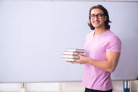 Young male student in front of boardの写真素材