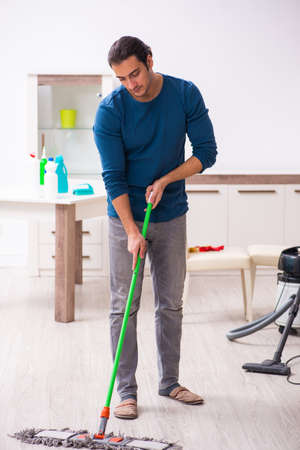 Young man husband doing housework at homeの写真素材