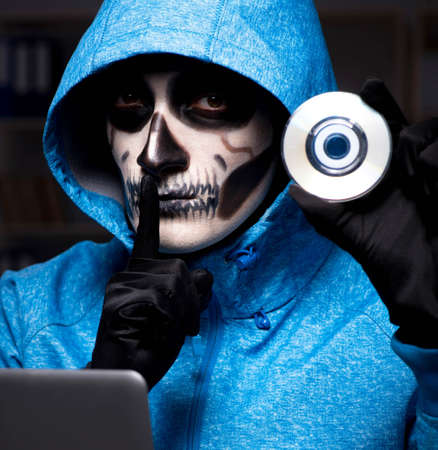 Scary hacker hacking security firewall late in officeの写真素材