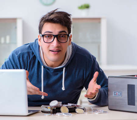 Young man mining bitcoins at homeの写真素材