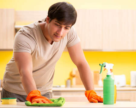 Single man cleaning kitchen at homeの写真素材