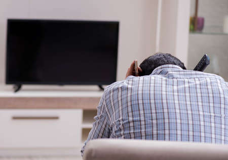 Young man watching tv at homeの写真素材