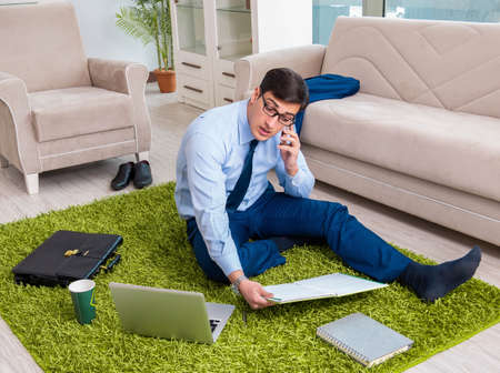 Businessman taking work home and working overtimeの写真素材