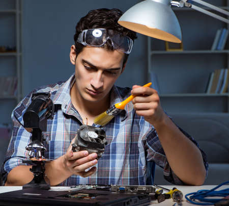 Computer repair man cleaning dust with brush