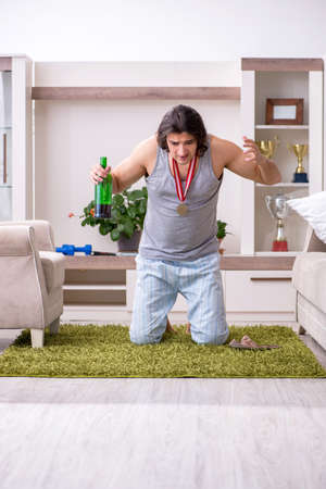Man ex-champion suffering from alcoholism at homeの写真素材