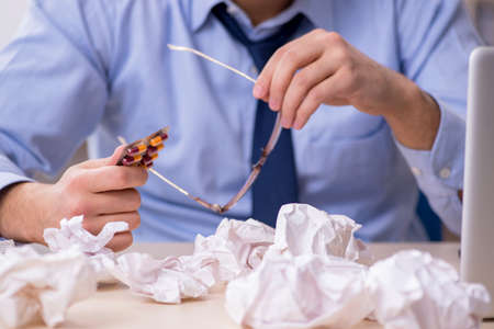Sick male employee suffering at workplace