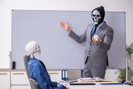 Funny business meeting with devil and skeletonsの写真素材