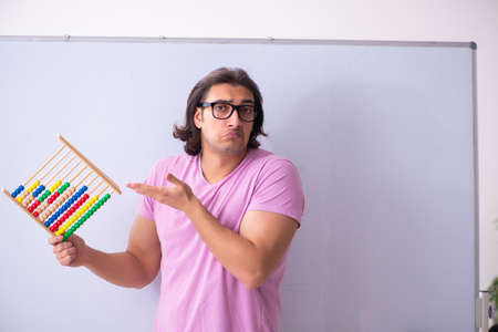 Young male student in front of board