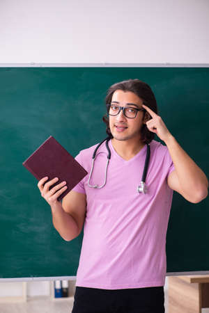 Young male student in front of boardの写真素材