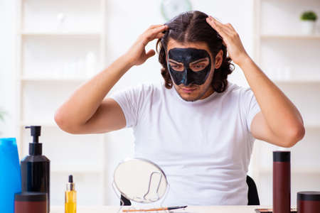 Young male cosmetician recording video for his blogの写真素材
