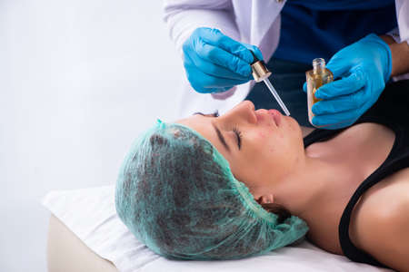 Young woman visiting male doctor dermatologistの写真素材