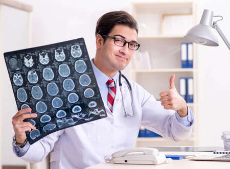 Young handsome doctor working in hospital roomの写真素材