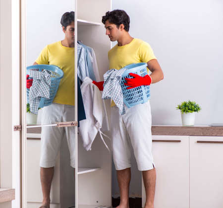 Young handsome man cleaning in the bedroomの写真素材