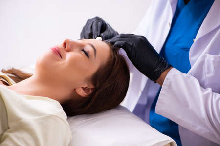 Young woman visiting male beautician in hair transplantation con