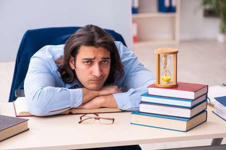 Young businessman student in time management conceptの写真素材