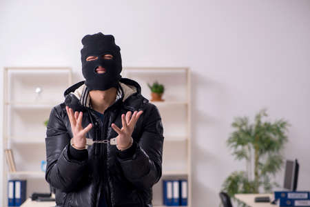 Young male burglar in the office