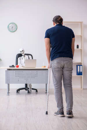 Young leg injured man visiting dead doctorの写真素材