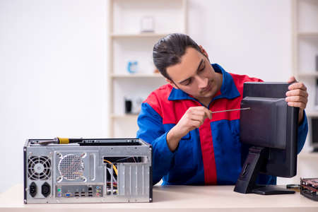 Young male repairman repairing computer