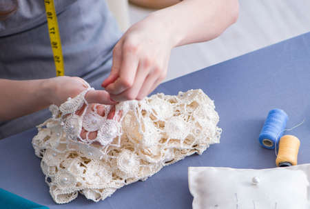 Woman tailor working on a clothing sewing stitching measuring fa