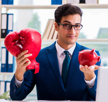 Businessman with boxing gloves angry in officeの写真素材
