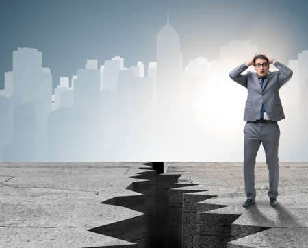 The businessman standing scared next to cliffの写真素材