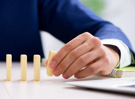 Young businessman playing with domino in office