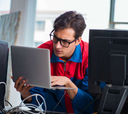 Computer repairman working on repairing computer in IT workshop