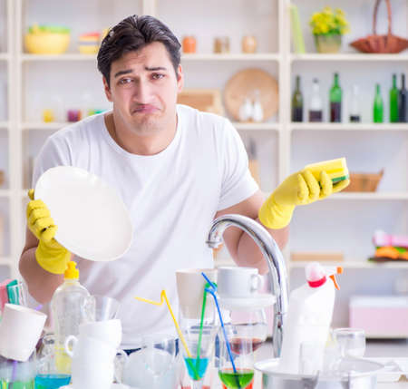 The man frustrated at having to wash dishesの写真素材