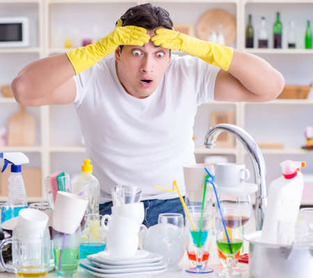 Man frustrated at having to wash dishesの写真素材