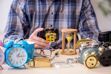 Young male watchmaker working in the workshop