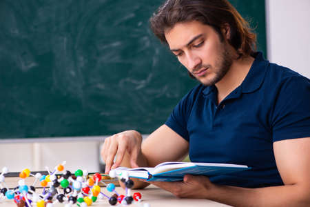 Young male scientist sitting in the classroom