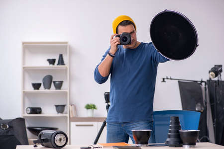 Young male photographer working in the studioの写真素材