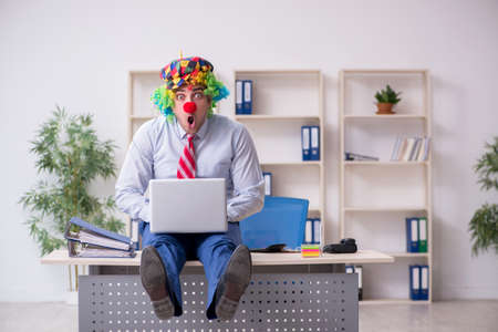 Funny employee clown working in the officeの写真素材