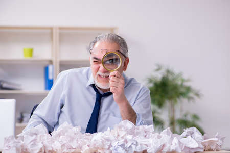 Old businessman rejecting new ideas with lots of papersの写真素材