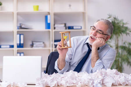 Old businessman rejecting new ideas with lots of papers