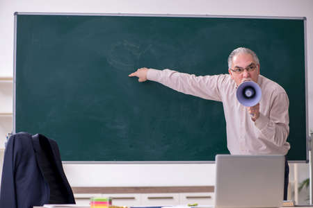 Old male teacher in the classroomの写真素材