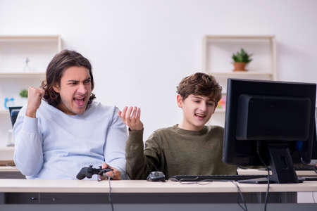 Father and son playing computer gamesの写真素材