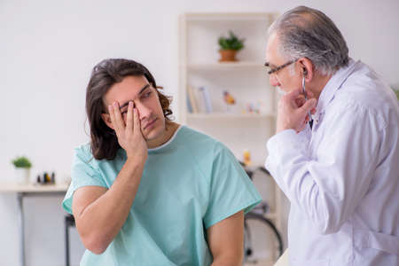 Young male patient visiting experienced doctorの写真素材