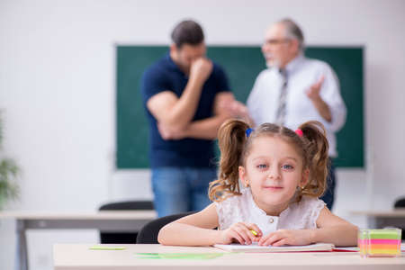 Young parent, old male teacher and little girl in the classroomの写真素材