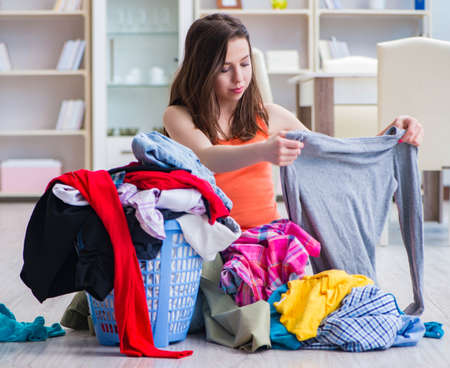 Stressed woman doing laundry at homeの写真素材