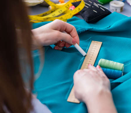 Woman tailor working on a clothing sewing stitching measuring faの写真素材