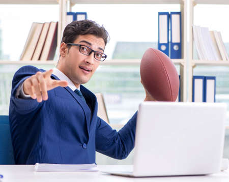 Businessman with american football in officeの写真素材