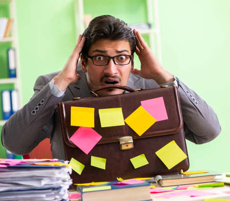 Businessman unhappy with many conflicting priorities sitting inの写真素材