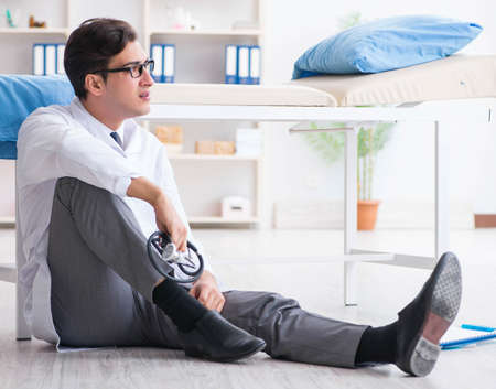 Doctor sitting on the floor in hospitalの写真素材
