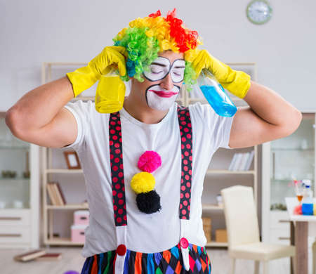 The funny clown doing cleaning at home