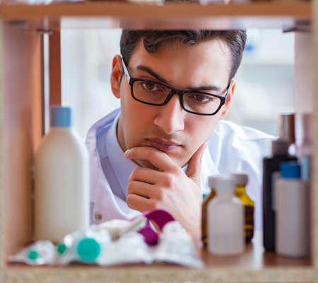 Doctor at farmacy retail shop looking for medicinesの写真素材