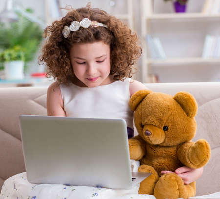 Little girl surfing internet on laptop